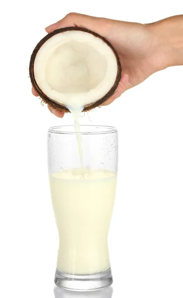 Main de femme verser du lait de coco dans un verre sur fond blanc — Photo