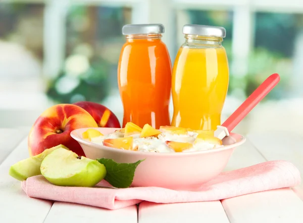 Tasty dieting food and bottles of juice, on wooden table — Stock Photo, Image