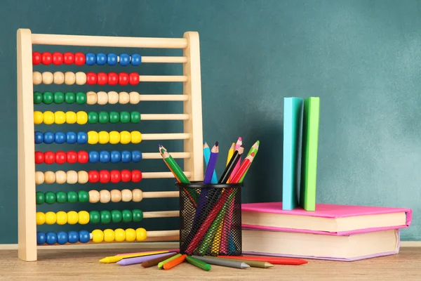 Brinquedo ábaco, livros e lápis na mesa, no fundo da mesa da escola — Fotografia de Stock