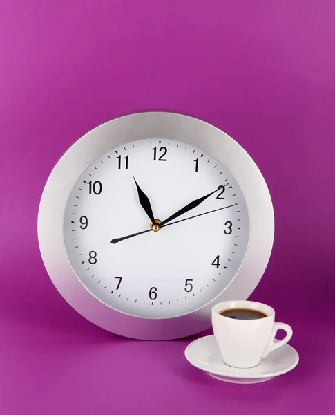 Cup coffee and clock on purple background — Stock Photo, Image
