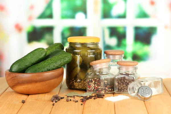 Tasty fresh and canned cucumbers, on wooden table on bright background — Stock Photo, Image