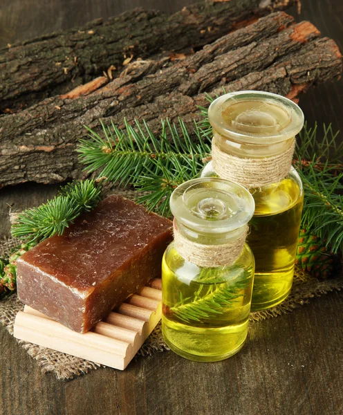 Jabón hecho a mano y botellas de aceite de abeto sobre fondo de madera — Foto de Stock