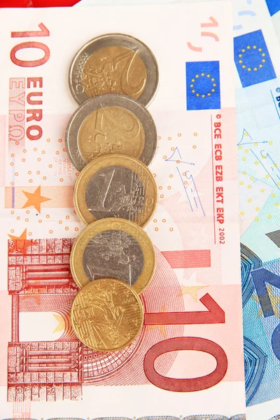 Euro banknotes and euro cents on red background — Stock Photo, Image