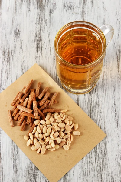 Beer in glass crunches, and nuts on wooden table — Stock Photo, Image