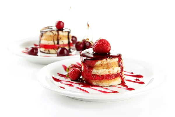 Gâteaux de biscuits savoureux avec confiture et baies sur des assiettes, isolés sur blanc — Photo