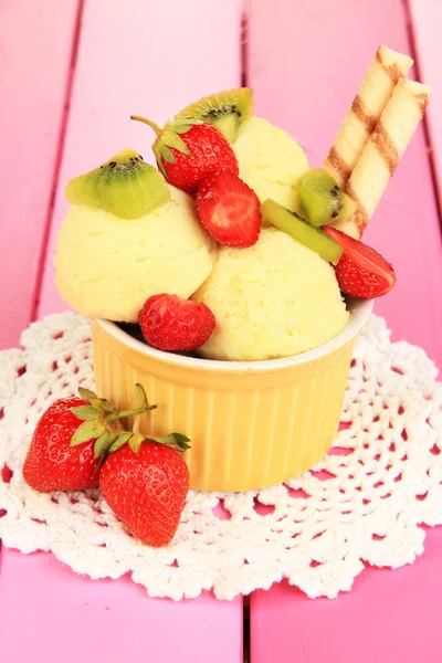 Delicioso helado con frutas y bayas en un tazón sobre una mesa de madera —  Fotos de Stock