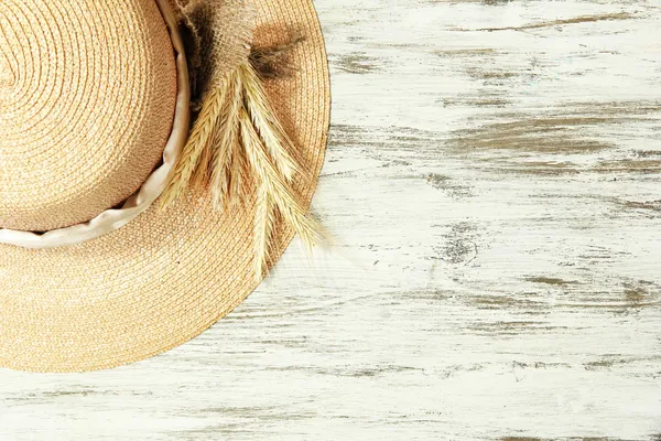 Beautiful summer hat with spikelets on wooden background — Stock Photo, Image