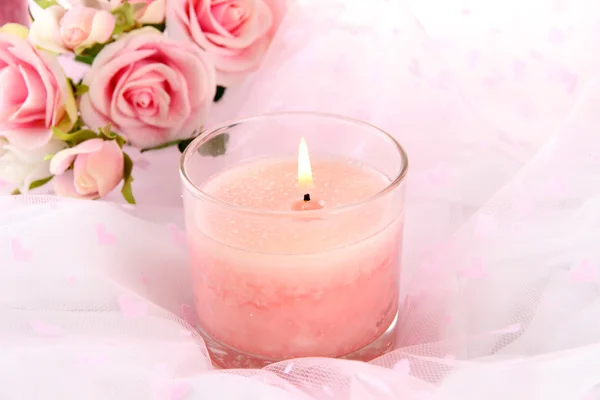 Beautiful candle with flowers on white cloth, close up — Stock Photo, Image