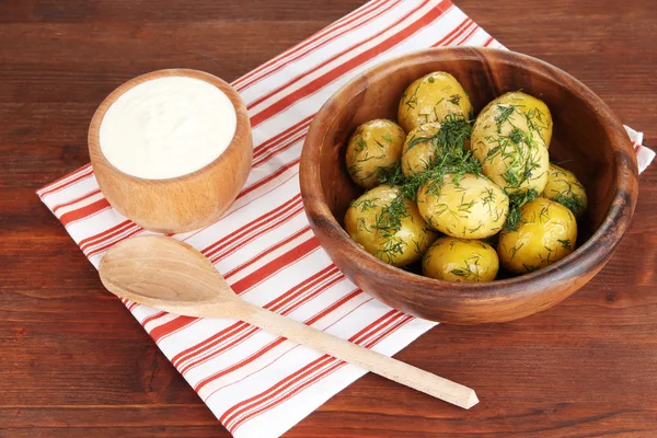 Boiled potatoes on wooden bowl on napkin on wooden table — Stock Photo, Image