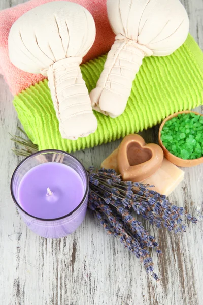 Natureza morta com vela de lavanda, sabão, bolas de massagem, sabão e lavanda fresca, sobre fundo de madeira — Fotografia de Stock