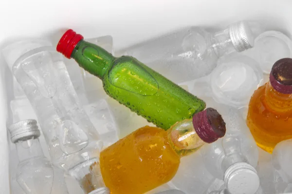 Minibar bottles with ice cubes, close-up — Stock Photo, Image