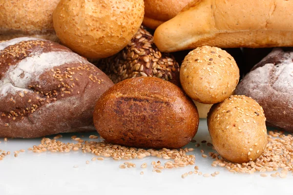 Deliciosos pães e trigo isolado em branco — Fotografia de Stock