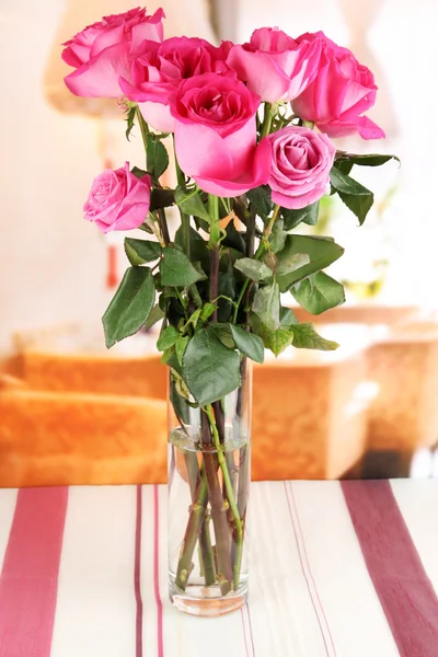 Beautiful pink roses in vase on table on room background — Stock Photo, Image