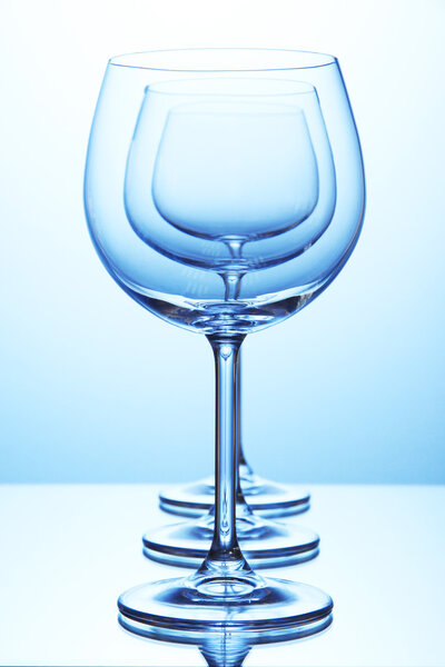 Empty wine glasses arranged on blue background