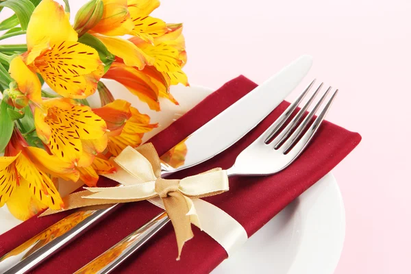 Ünnepi asztal beállítás virágok rózsaszín háttér — Stock Fotó