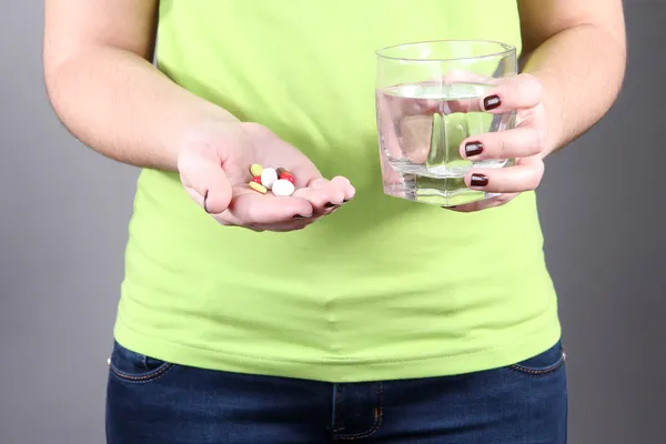 Many pills and glass water in hand — Stock Photo, Image