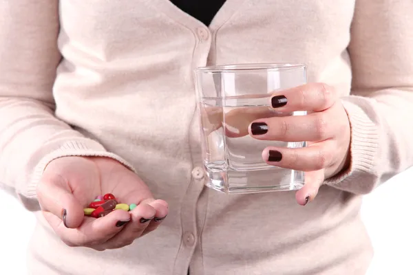 Muitas pílulas e água de vidro na mão — Fotografia de Stock