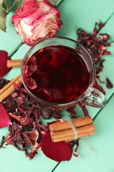 Tisane dans une tasse en verre, sur fond de bois couleur — Photo