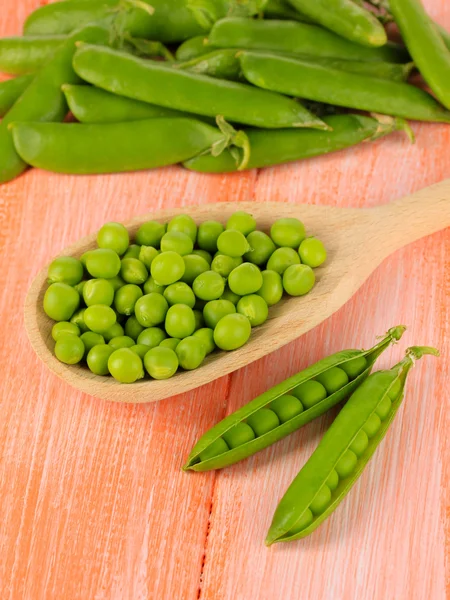 Guisantes verdes dulces sobre fondo de madera — Foto de Stock