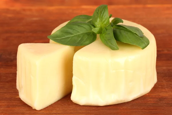 Cheese mozzarella and basil on wooden background — Stock Photo, Image