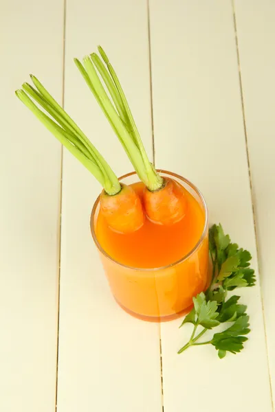 Vaso de jugo de zanahoria, sobre fondo de madera de color —  Fotos de Stock