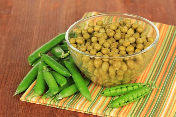 Guisantes verdes sobre fondo de madera — Foto de Stock