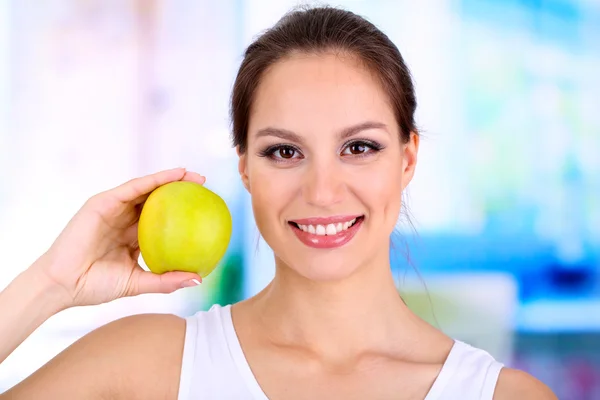 Lächelnde Frau mit Apfel auf hellem Hintergrund — Stockfoto