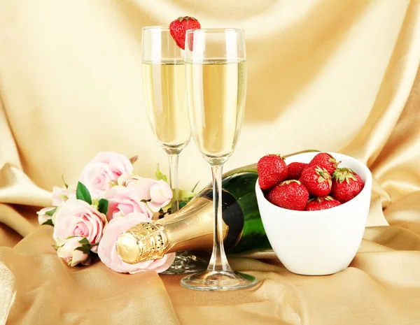 Bodegón romántico con champán, fresa y rosas rosadas, sobre fondo de tela de color — Foto de Stock