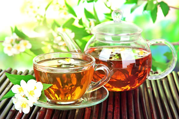 Cup of tea with jasmine, on bamboo mat, close-up — Stock Photo, Image