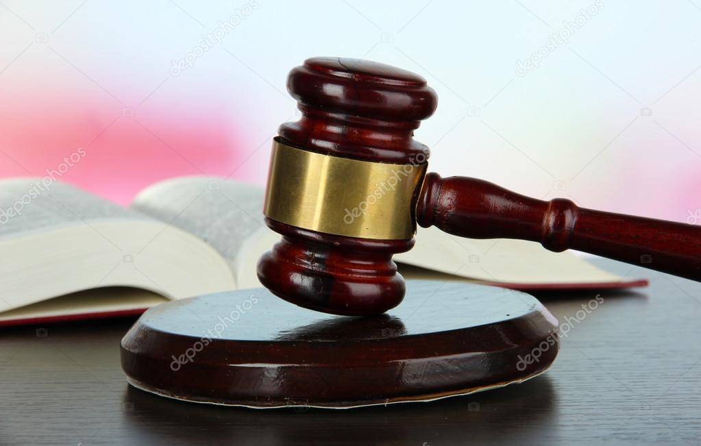 Gavel and book on table on light background