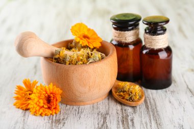 ilaç şişeleri ve ahşap zemin üzerine calendula çiçekler