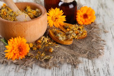 ilaç şişeleri ve ahşap zemin üzerine calendula çiçekler