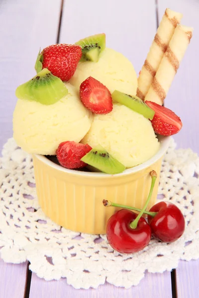 Delicious ice cream with fruits and berries in bowl on wooden table — Stock Photo, Image