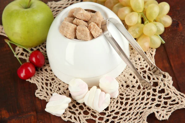 Unrefined sugar in white sugar bowl on wooden background — Stock Photo, Image