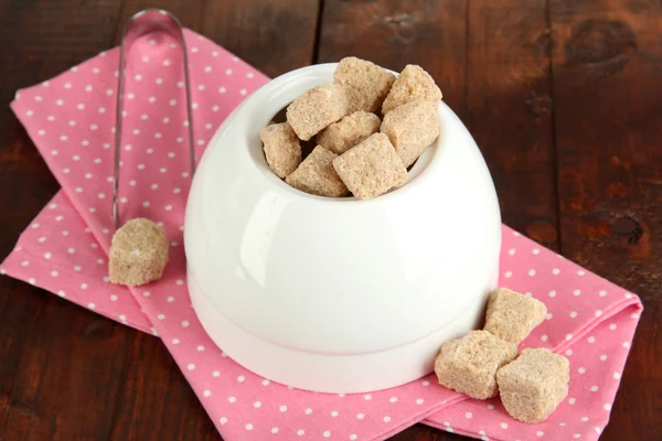 Unrefined sugar in white sugar bowl on wooden background — Stock Photo, Image