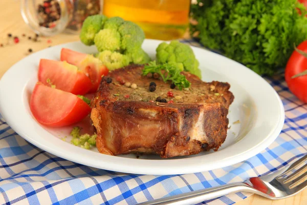 Piece of fried meat on plate on wooden table close-up — Stock Photo, Image