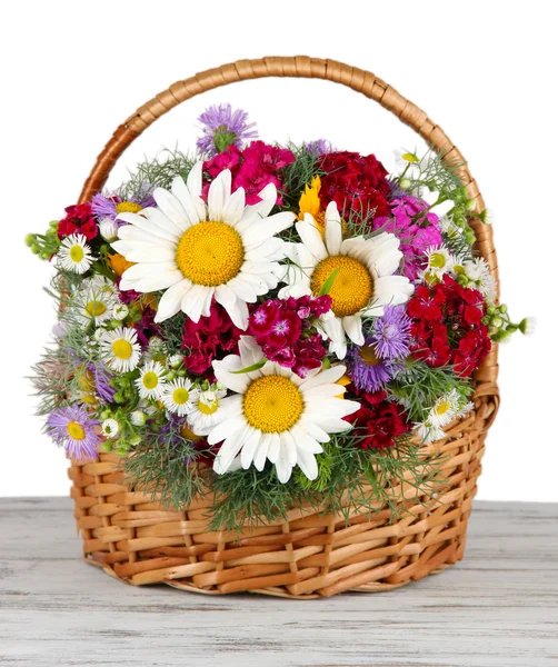 Schöne helle Blumen in Weidenkorb auf dem Tisch auf grauem Hintergrund — Stockfoto