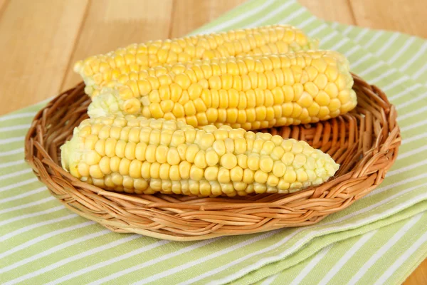 Verse maïs op rieten mat, op houten achtergrond — Stockfoto