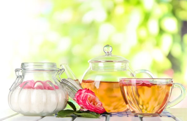 Tetera y taza de té de rosa de té en la servilleta en la mesa de madera en el fondo de la naturaleza —  Fotos de Stock