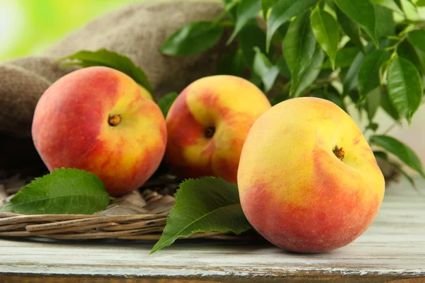 Спелые сладкие персики на деревянном столе в саду, закрыть — стоковое фото