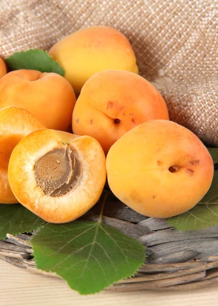 Apricots on wicker coasters on wooden table — Stock Photo, Image