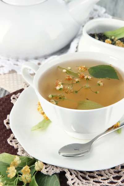 Tasse Tee mit Linden auf Servietten auf Holztisch — Stockfoto
