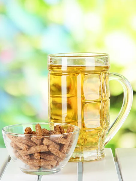Beer in glass and croutons on table on nature background — Stock Photo, Image