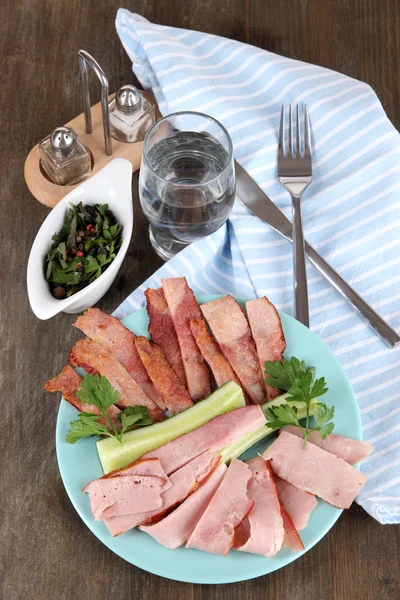 Bacon on plate on napkin on board on window table — Stock Photo, Image