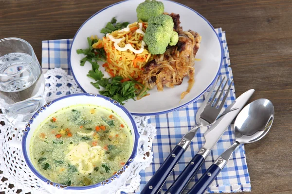 Sopa y arroz con carne en platos sobre servilletas sobre mesa de madera — Foto de Stock