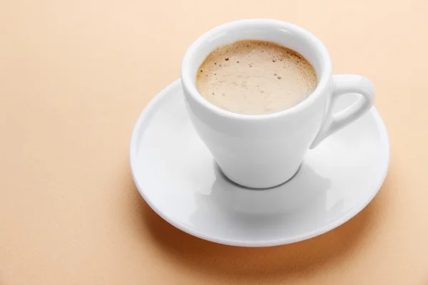 Cup of coffee on beige background — Stock Photo, Image