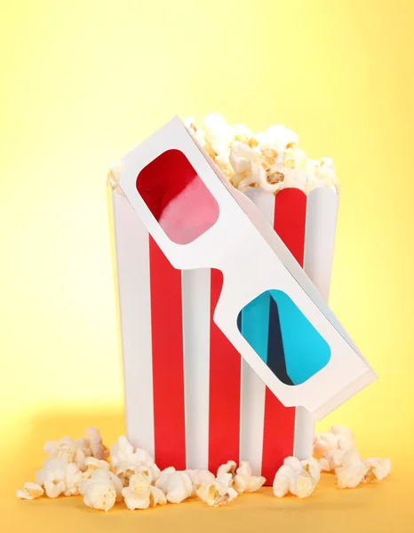 Popcorn en 3D-bril op gele achtergrond — Stockfoto