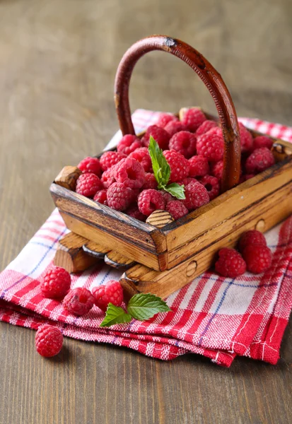 Ripe sweet raspberries in basket on wooden background — Stock Photo, Image