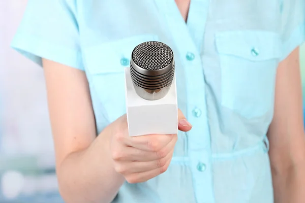 Femme avec microphone sur fond de pièce — Photo