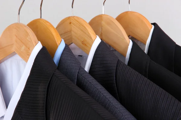 Pakken met shirts op hangers op lichte achtergrond — Stockfoto